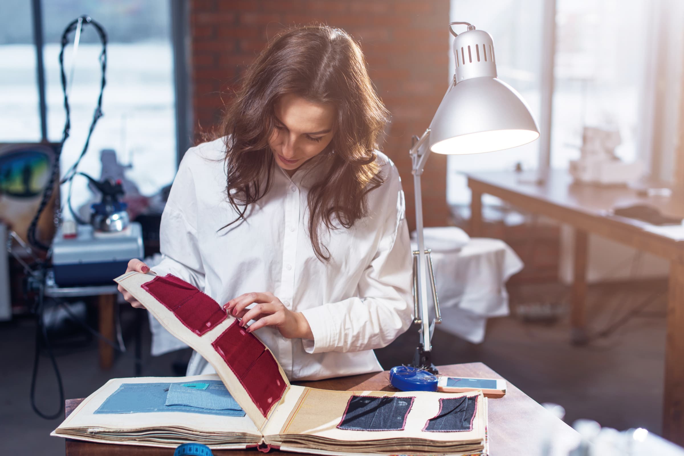 Designer reviewing fabric swatches and material samples during activewear product development