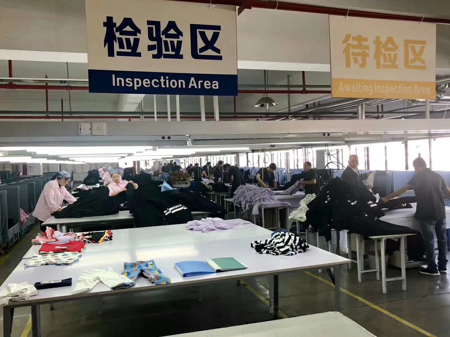 Real garment inspection area reviewing activewear before repeat-order packing