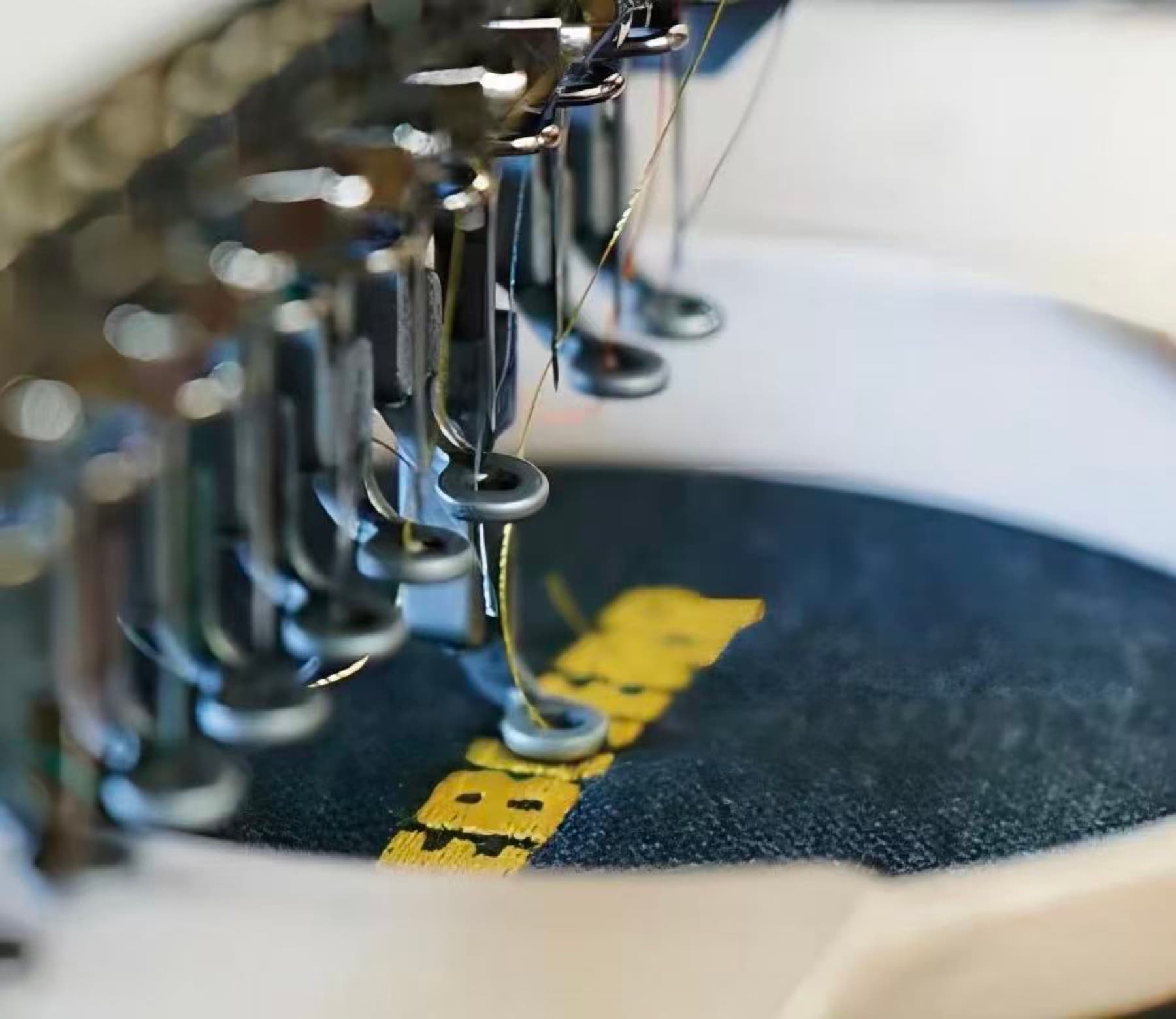 Embroidery machine applying a private-label detail to a technical garment for an OCR apparel collection