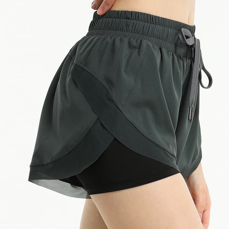 Layered two-in-one training shorts with an outer overlap panel and inner short