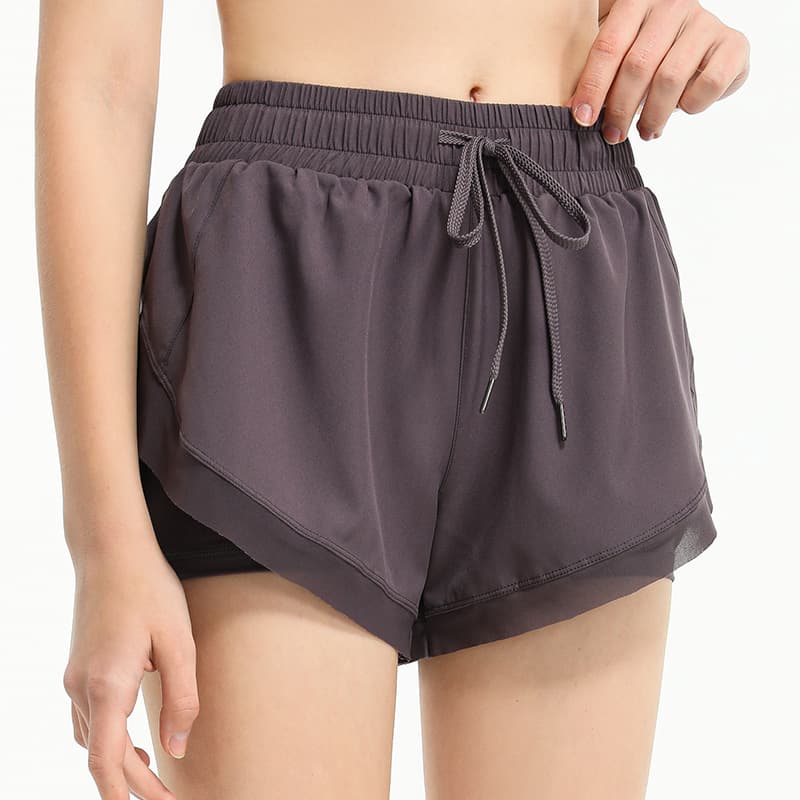 Layered two-in-one training shorts with an outer overlap panel and inner short view 3