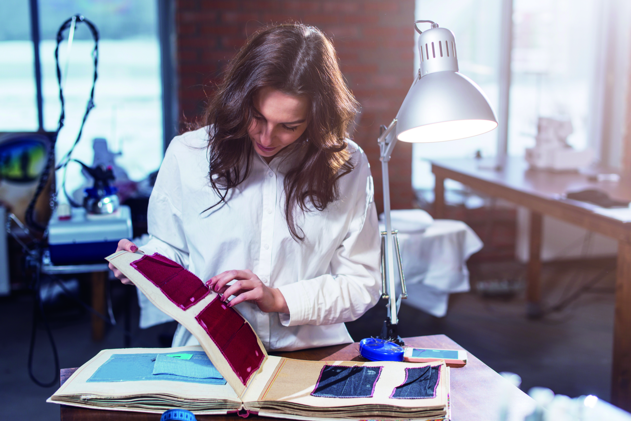 Designer reviewing fabric swatches and material samples during activewear product development