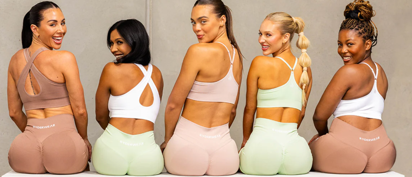 Cinque modelli indossano reggiseni sportivi e leggings Ryderwear coordinati in colori neutri e pastello