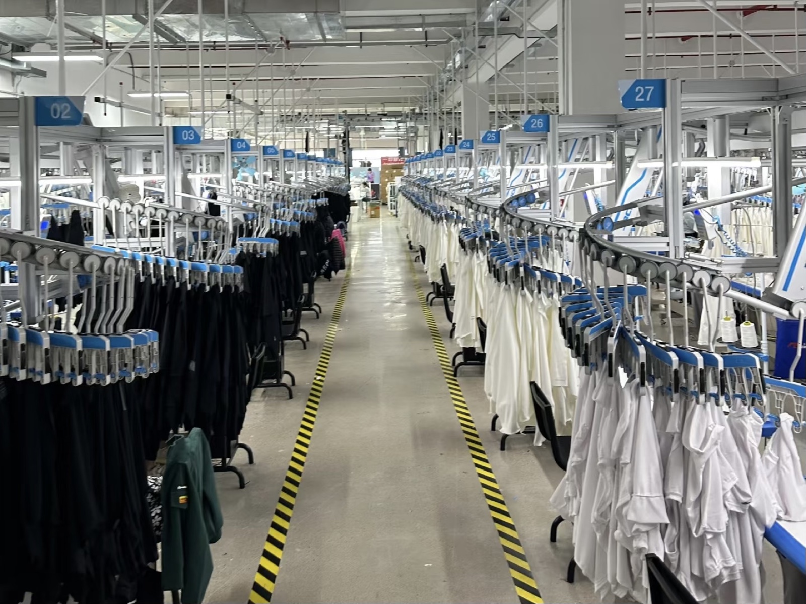 Activewear garments moving through a Chinese factory hanging-production line