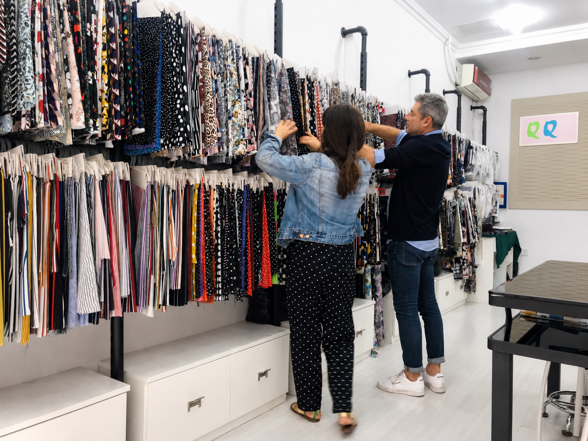 Real fabric showroom review with activewear material swatches arranged by color