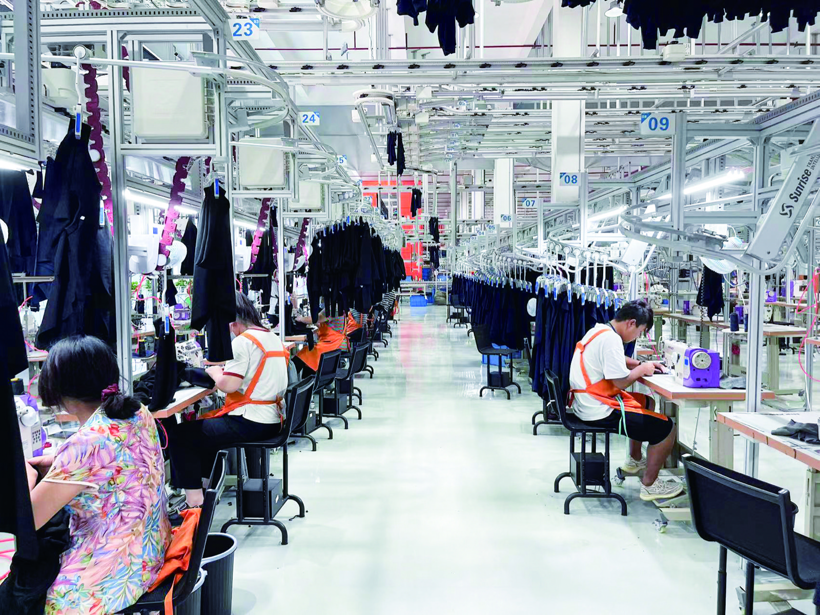 Activewear production floor with sewing workstations and hanging garments