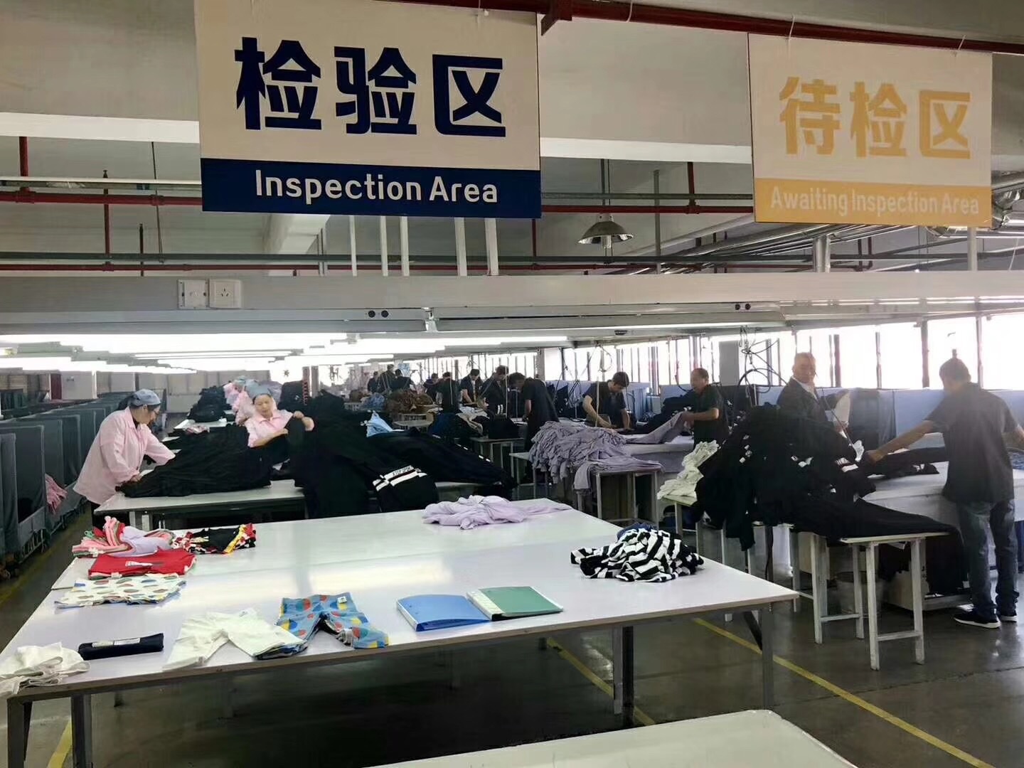Real garment inspection area reviewing activewear before repeat-order packing