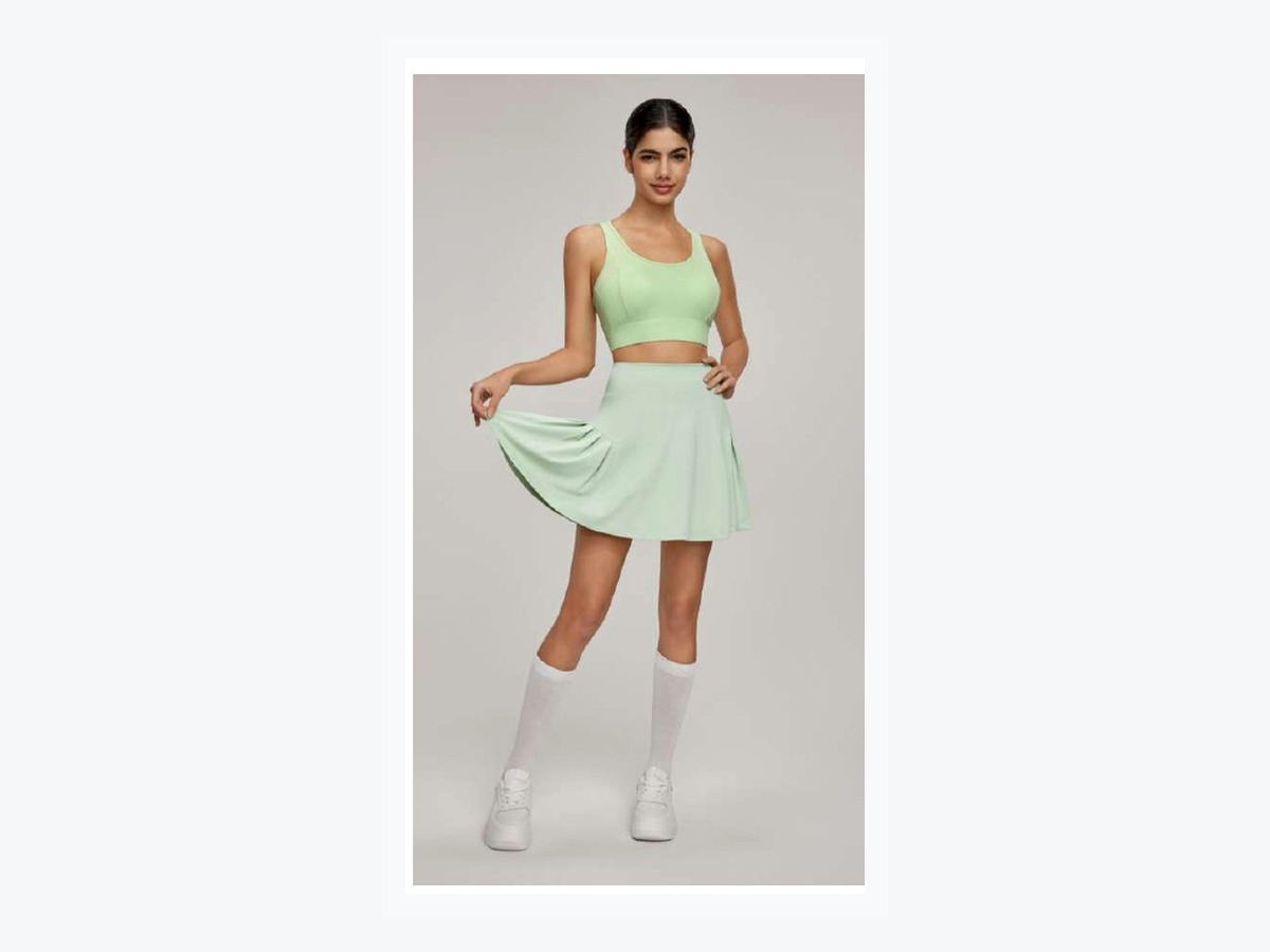 Green pleated court skirt shown with a coordinated top as an outer-silhouette reference